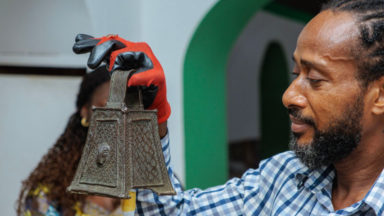 Olusegun Adeleye carefully lifts one of the restituted ceremonial bells. The Ẹroro (bells) were rung to invoke the ancestors during ceremonies at the altars of dignitaries and the king.